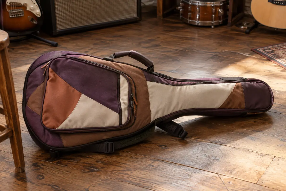 Housse multicolore en polyester pour guitare électrique, avec poche avant, poignée latérale et bretelles réglables.