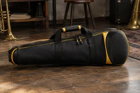 Étui souple noir et jaune pour trompette, avec doublure rembourrée et protection renforcée au pavillon.